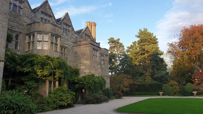 trees turning orange surround a stately home